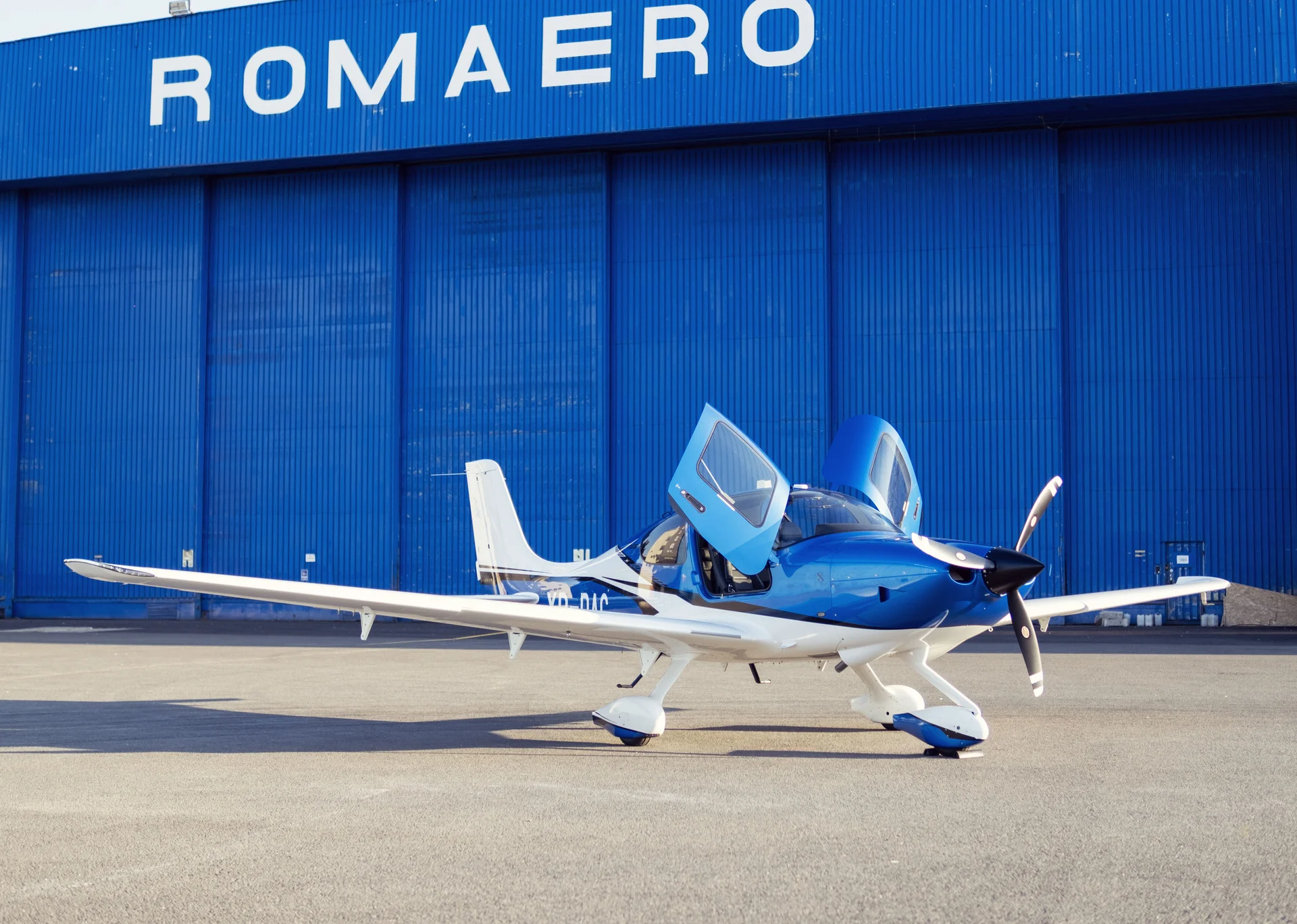 Cirrus SR20 G7 — blue and silver on the ramp at Cirrus Aviation Romania